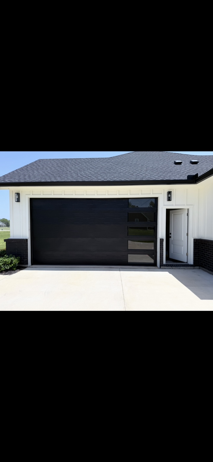 Modern black residential garage door with side windows